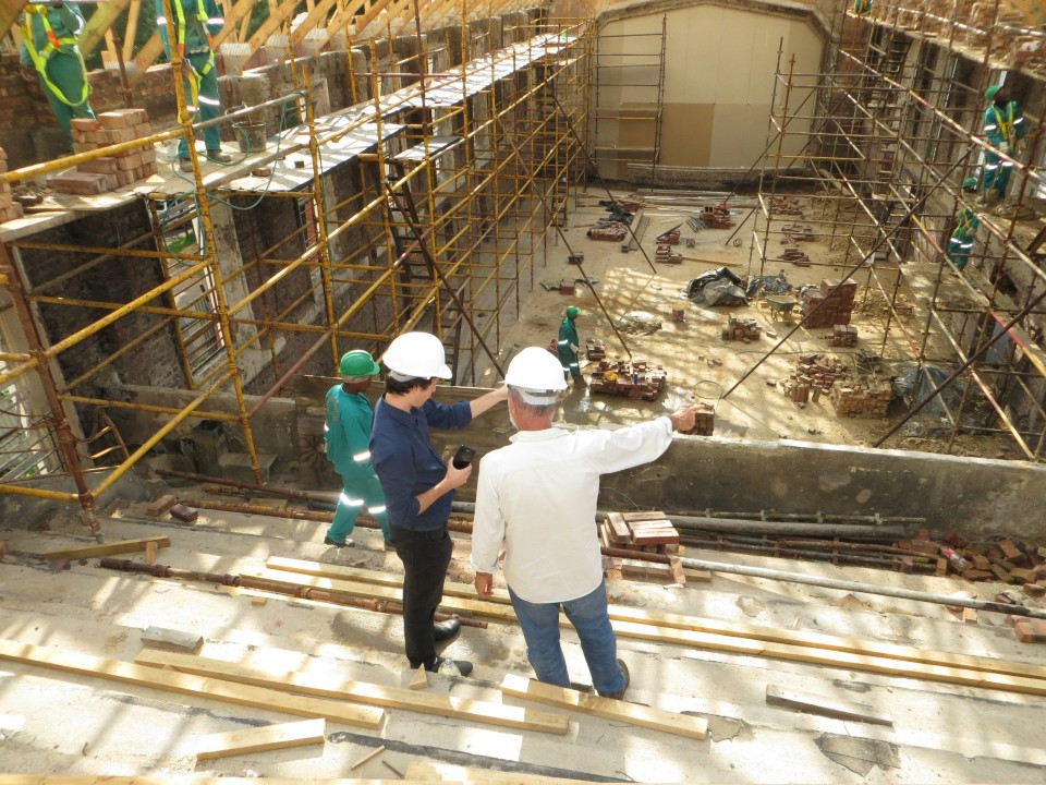 Two men overseeing construction inside building.