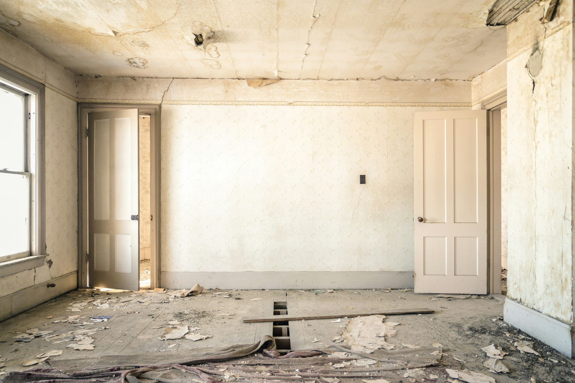 Empty room with peeling paint and doors.